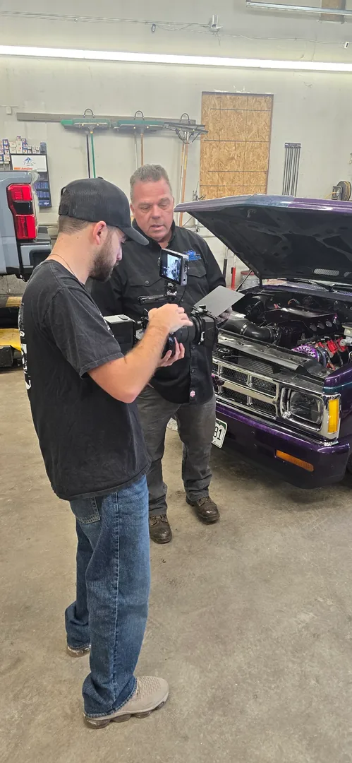 Brandon Easton reviewing footage with a client in an auto shop